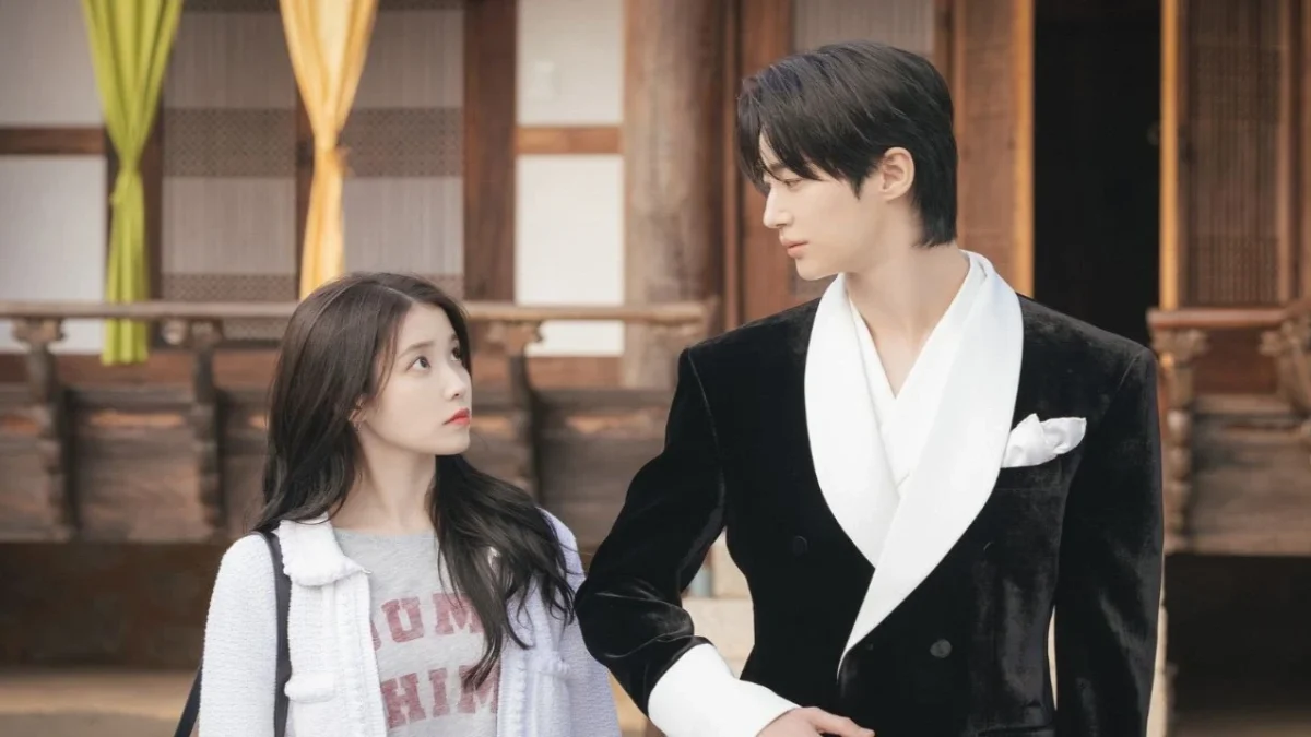 The long awaited romance drama Perfect Crown starring IU and Byeon Woo Seok has finally shared its release plans. The series will air worldwide on Disney Plus. The announcement was made during the Disney Originals event in Hong Kong. Along with the platform reveal fans also got their first official look at the lead characters. The new stills show IU as Sung Hee Joo and Byeon Woo Seok as Grand Prince Yi Wan. This is their first major pairing after their brief couple moment in Moon Lovers Scarlet Heart Ryeo where Byeon Woo Seok made a cameo. A lot has changed since then. Byeon Woo Seok became massively popular after Lovely Runner and is now landing big dramas thanks to his breakout performance. In Perfect Crown also known earlier as Wife of 21st Century Prince IU plays a smart beautiful and confident chaebol heiress. She seems to have everything but she lives in an alternate version of modern Korea that follows a constitutional monarchy. That means she actually holds very little real power. Byeon Woo Seok plays a neglected Grand Prince who despite being royal has almost no influence. He deeply wants the power he lacks. The two characters end up getting into a contractual marriage. They start off as total opposites with different goals but slowly begin to connect. Their fake relationship turns into real feelings. This sets the stage for a romance filled with longing tension and emotional moments. The newly released stills show IU as a stylish strong woman and Byeon Woo Seok as a striking prince. They must work together for their own benefit but love starts growing between them.